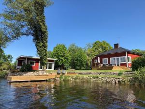 una casa junto a un río con una casa en Ferienhaus mit Garten und Holzterrasse direkt am See 