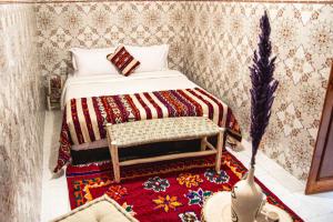 Dormitorio pequeño con cama y alfombra en Riad Fz Marrakech, en Marrakech