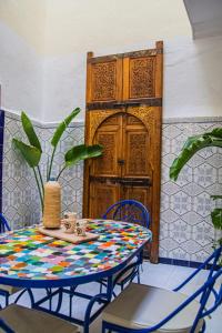 - une table et des chaises dans une pièce avec porte dans l'établissement Riad Fz Marrakech, à Marrakech