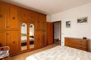 1 dormitorio con armarios de madera, 1 cama y vestidor en Appartamento vista Alpi biellesi, en Biella