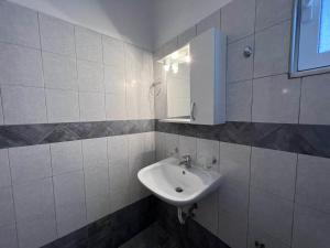 Baño blanco con lavabo y espejo en Triton Rooms, en Lefkandi Chalkidas