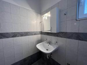 a white bathroom with a sink and a mirror at Triton Rooms in Lefkandi Chalkidas