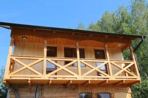 a large wooden cabin with a gambrel roof at Gutsulochka Apartment in Yaremche