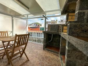 uma sala de jantar com uma mesa e uma lareira de pedra em Matriz Guest House na Ribeira Grande