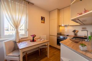 a small kitchen with a table and a window at Flexible SelfCheckIns 43 - Zagreb - Luxury - Parking - Loggia - Brand New in Zagreb