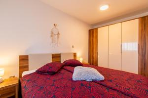a bedroom with a bed with a red blanket at Flexible SelfCheckIns 43 - Zagreb - Luxury - Parking - Loggia - Brand New in Zagreb
