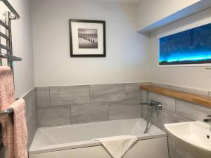 a bathroom with a bath tub and a sink at Modern Apartment in Latitude52 Dockyard & parking in Plymouth