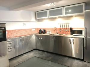 a large kitchen with stainless steel cabinets and appliances at Modern Apartment in Latitude52 Dockyard & parking in Plymouth