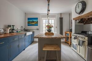 a kitchen with blue cabinets and a clock on the wall at The Broadstairs Townhouse in Broadstairs