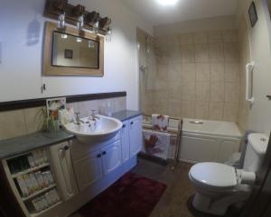 a bathroom with a sink and a toilet and a tub at Beldy Chapel Ground floor apartment in Alston