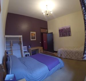 a bedroom with a large blue bed and a table at Beldy Chapel Ground floor apartment in Alston