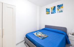 a bedroom with a blue bed in a white room at Lovely Apartment In Marina Di Strongoli With House Sea View in Marina di Strongoli
