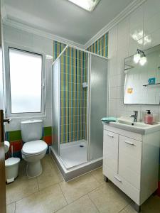 uma casa de banho com um chuveiro, um WC e um lavatório. em Matriz Guest House na Ribeira Grande
