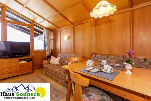 ein Wohnzimmer mit einem Tisch und einem TV in der Unterkunft Haus Sonneck Ferienwohnungen GbR in Reit im Winkl