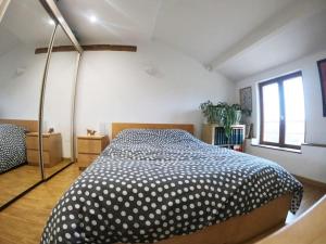 1 dormitorio con 1 cama con manta de lunares en Les Gîtes de Chérisey, en Chérisey