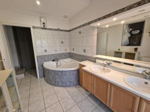 a large bathroom with two sinks and a tub and a tub at Les Gîtes de Chérisey in Chérisey