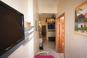 TV de pantalla plana colgada en la pared de la sala de estar. en Apartment in Copacabana, en Río de Janeiro