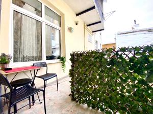 a patio with a table and chairs and a hedge at Casa Irina in Braşov