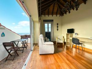 a living room with a table and chairs at Matriz Guest House in Ribeira Grande