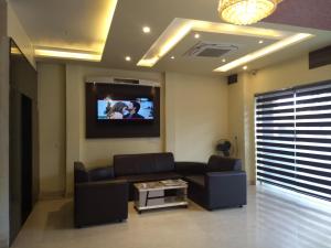a living room with a couch and a tv on the wall at The Royal Chandra in Samastīpur