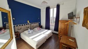 a bedroom with a bed with a mirror and a blue wall at Constantin in Arles