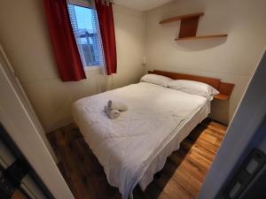 una piccola camera con un letto bianco e una finestra di Campeggio Don Bosco a Lido di Jesolo