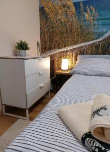 two beds in a room with a dresser and a bedroom at Apartament ZatokaPuck in Puck