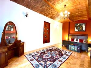 Sala de estar con alfombra en el suelo y espejo en Casa Irina, en Brasov