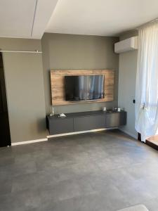 sala de estar con TV de pantalla plana en la pared en La Casa di Davide Milano Monza en Concorezzo
