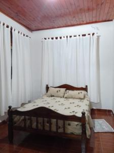 Cama en habitación con cortinas blancas en La Casa de Estela en La Paz