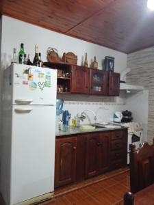 a kitchen with a white refrigerator and wooden cabinets at La Casa de Estela in La Paz