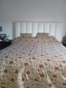 a bed with a floral comforter on top of it at La Casa de Estela in La Paz