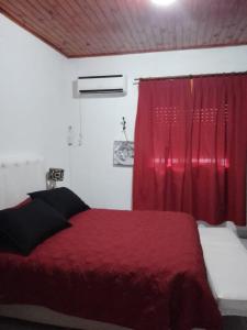 a bedroom with a red bed and a red curtain at La Casa de Estela in La Paz
