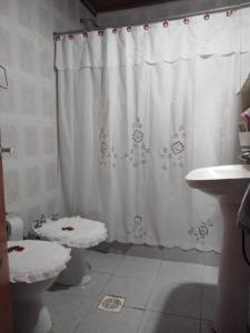 a bathroom with a white shower curtain and a toilet at La Casa de Estela in La Paz