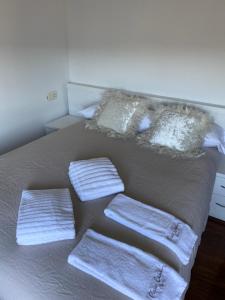 a bed with three pillows and towels on it at Moment Collector in Ourense