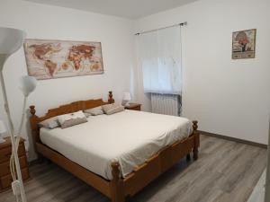 1 dormitorio con 1 cama con sábanas blancas en appartamento la pineta 10058-LT-0004, en Serra Rocco
