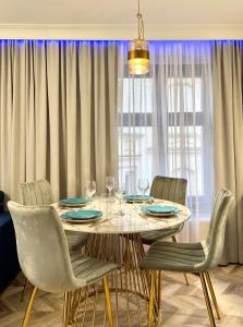 comedor con mesa, sillas y ventana en BelleView Apartment, en Toruń