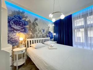 1 dormitorio con cama blanca y pared de flores en BelleView Apartment, en Toruń
