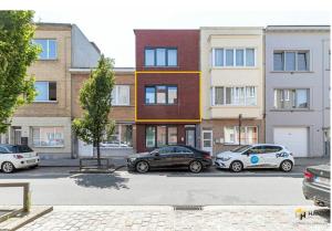een groep auto's geparkeerd voor een gebouw bij NSD Home in Antwerpen