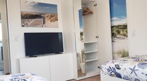 a bedroom with a tv in a white wall at Ferienwohnung in Stelle bei Familie Thieshen in Stelle