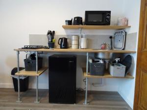 a kitchen with a table with a microwave and acomputer at Modern Barn Conversion in Brackley