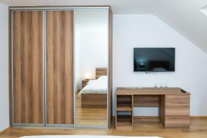 a bedroom with a sliding glass door with a desk and a tv at Guest House Alte in Kolašin
