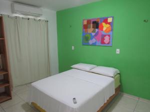 a green room with two beds and a painting on the wall at Flats Condominio Professor Wilson in Teresina