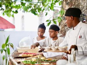 a group of people standing around a table with food at Kahawa house in Zanzibar City