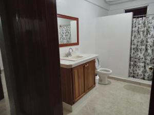 y baño con lavabo y aseo. en Hostel Casa Verde, Tela Atlantida. en Tela