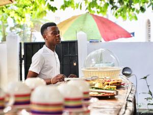 a man standing in front of a table with food at Kahawa house in Zanzibar City
