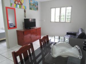 ein Wohnzimmer mit einem Esstisch und einem TV in der Unterkunft Flats Condominio Professor Wilson in Teresina