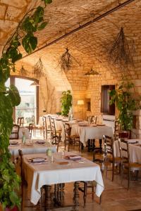 a dining room with tables and chairs in a building at Masseria San Paolo Grande in Ostuni