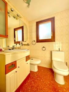 a bathroom with a sink and a toilet and a mirror at Apartamento La Zahora - Alcañiz in Alcañiz