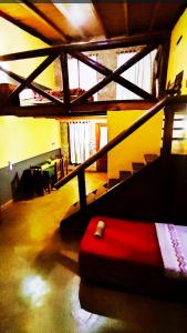 een kamer met een rood bed in een kamer met een trap bij Hotel Village del Sol in Puerto Iguazú